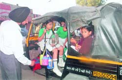 Balbir Singh, DTO, Mohali, challans an overloaded auto-rickshaw, ferrying schoolchildren, in Mohali 