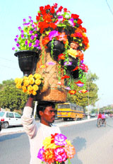 A man sells artificial flowers on a road in Jalandhar on Thursday.