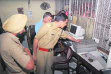 Police officials inspect a room of the general post office in Jalandhar from where robbers looted Rs 40 lakh on Wednesday.