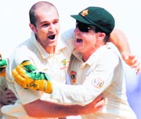 Australia's off-spinner Jason Krejza (L) celebrates with wicketkeeper Brad Haddin after taking the wicket of India's Rahul Dravid (not pictured) in Nagpur