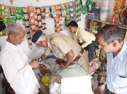 Police officials examine the body of a man who was found murdered at Jharsa village in Gurgaon on Friday morning.