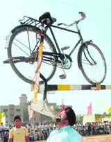 Major Singh balances a bicycle tied to a plough during rural sports in Mohali on Sunday