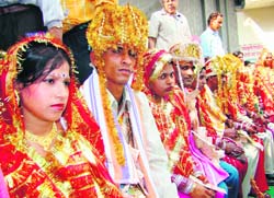 Newly-wed couples at a mass marriage ceremony organised by the Shiv Mandir Sabha in Karnal on Sunday. Eleven poor couples tied the knot. 