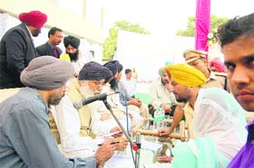 Parkash Singh Badal listens to complainants during a sangat darshan programme in Ludhiana