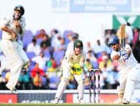 Mahendra Singh Dhoni (R) plays a shot as Australias wicket keeper Brad Haddin (C), and Mike Hussy watch during the fourth Test on Sunday. 