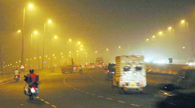 FOGGY DAYS AHEAD: Motorists face difficulty in driving as fog engulfs the Delhi-Gurgaon highway on Sunday. 