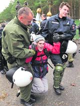 An anti-nuclear protester sings as she is carried away by German riot police after the authorities ended a road blockade and sit-in outside Germany's interim nuclear waste storage facility in the northern German village of Gorleben