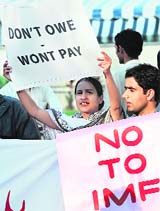 Pakistani protesters carry placards as they shout anti-International Monetary Fund (IMF) and World Bank slogans during a protest in Islamabad