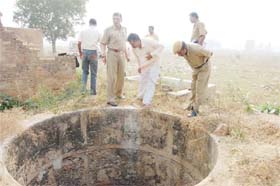 Gurgaon police personnel inspect the well at Wazirabad in Gurgaon in which the body of a 24-year-old man was found
