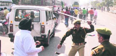 A cop beats up Gurdeep Singh, LJP candidate from Gandhi Nagar, during a protest in front of the PDP office in Jammu on Wednesday. 