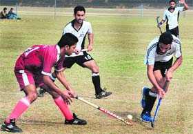 Players vie to snatch the ball during a hockey match between GHG Khalsa College, Gurusar Sadhar, and Government College, Ludhiana, at PU grounds
