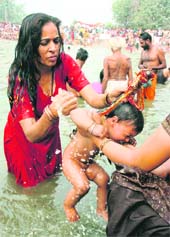 A child takes a holy dip during Jhiri fair on the outskirts of Jammu. The mela is organised in November to commemorate the martyrdom of Jitu Baba, who had committed suicide in protest against the attrocities of his landlord.