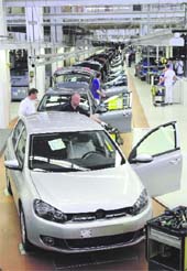 Employees work on the bodywork of Volkswagen's new Golf VI car during a photocall in a production line at the Volkswagen headquarters in Wolfsburg on Friday. It is up to the European Commission to decide if the changes that Germany made to a law on governing Volkswagen meets its requirements, a spokeswoman for the Justice Ministry said on Friday.