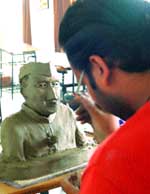 A student gives final touches to the clay model of Chacha Nehru during a competition in Jalandhar 