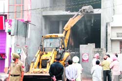 Municipal corporations JCB machine demolishes a structure in Ludhiana