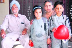 Arman Preet Singh and Sazel Preet Kaur with their grandparents Baldev Singh and Santosh Kaur at Alowal village in Hoshiarpur