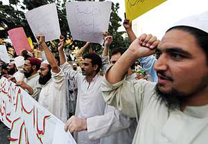 Pakistani journalists carry placards as they shout slogans against the ban of two Islamic newspapers in Karachi on Saturday.