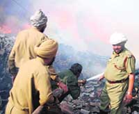 Fire fighters try to douse the fire at a woollen mill in Dhandri Kalan on Sunday.