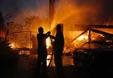 Residents help with garden hoses as a neighbours home burns to the ground in Yorba Linda, California, on Saturday.