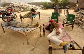 Punjab police personnel deployed to maintain order at the place where a land dispute had arisen enjoy a quiet nap in Bathinda