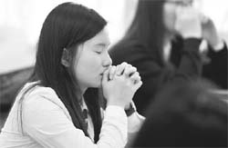 A South Korean student praying prior to taking the College Scholastic Ability Test for college entrance, at an exam hall in Seoul on November 13 Photo: AFP