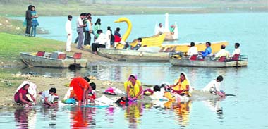 Local women wash clothes even as tourists go boating in the Damadama Lake in Gurgaon