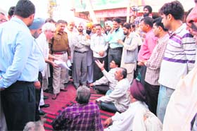 Shopkeepers stage a dharna demanding immediate repair of the Lalheri road in Khanna