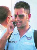 England cricketers (left) and MS Dhoni arrive for the 3rd ODI against India at Lucknow airport on Tuesday.