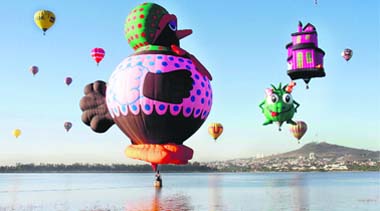 Hot-air balloons fly over the Palote dam during the Hot air Balloons Festival in the city of Leon, Mexico