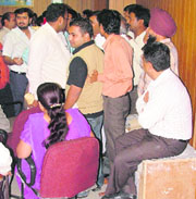 A contractor sits on a box to refrain other contractors from submittting tenders in Ludhiana on Wednesday.