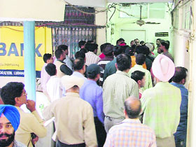 Contractors wait for their turn for submitting tenders outside superintending engineers office in Ludhiana on Wednesday.