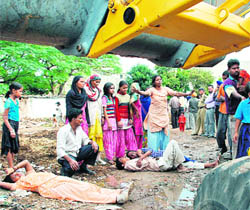 Residents of Madanpur village lie in front of a JCB machine during a demolition drive in Mohali on Thursday.