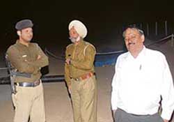 Police officers cordon off the area from where the charred body was recovered in Sarangpur village on Friday. 