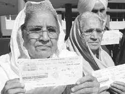 1984 riots victims with cheques received from Jasjeet Singh Banni, chairman, Punjab Cooperative Bank, in Mohali on Friday.