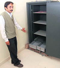 A bank employee shows an empty chest at the Haryana Gramin Bank in Kunjpura in Karnal on Friday.