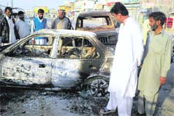 People inspect a blast site in Dera Ismail Khan on Friday. A bomb attack killed at least 10 persons and wounded 40 at the funeral of a Shia Muslim on Friday in the northwest Pakistani town.
