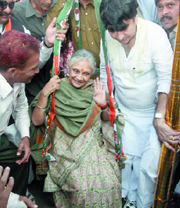 Chief Minister of Delhi Sheila Dikshit is weighed against coins by her supporters during an election campaign for Haroon Yusuf (R) on Saturday.