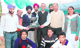 The winning team of Multani Mal Modi College receives the trophy on the concluding day of the Punjabi University Inter-College Lawn Tennis Championship in Patiala on Sunday.