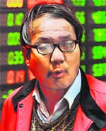 A Chinese investor stands in front of a stock price board showing falling prices at a private security firm in Shanghai 