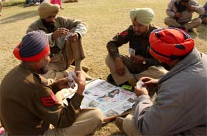 Cops on duty at the fifth heritage fair play cards to pass their time in Bathinda.Tribune photo: Kulbir Beera