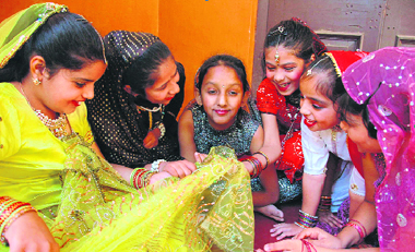 Girl participants at a cultural function in Dehradun discuss their dresses.