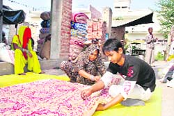 A mother-son duo stitches a quilt in Hisar, anticipating brisk sales in the 