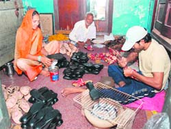 Members of a family make shoes in Karnal.