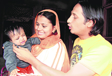 Seaman Bijender Singh with his wife and child at their residence in Kharawar village in Rohtak on Tuesday.