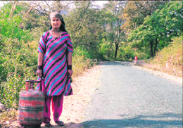 A woman waits for LPG supply along the Dharamsala-Chari road.