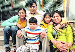 Prabhat Goyal, captain of 'MV Stolt Valor', which was hijacked by pirates at Somalia, with his wife Seema and children, pose for the media on his safe arrival, in New Delhi