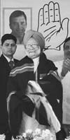 Prime Minister Manmohan Singh in a traditional jacket waves to supporters during an election rally at Aizawal in Mizoram