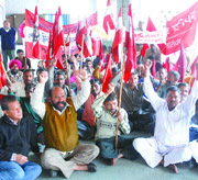 Members of trade unions protest outside the assistant labour commissioners office in Jalandhar on Wednesday.