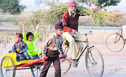 A farmer takes along his children back home after a day’s hardwork in a