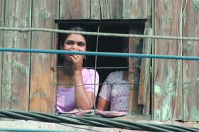A resident looks through a dilapidated window at G.B. Road in New Delhi